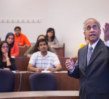 Lecturer lectures students in classroom.